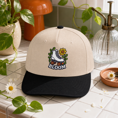 Bloom Roller Skate embroidered hat in Black / Natural on a plant care tile counter