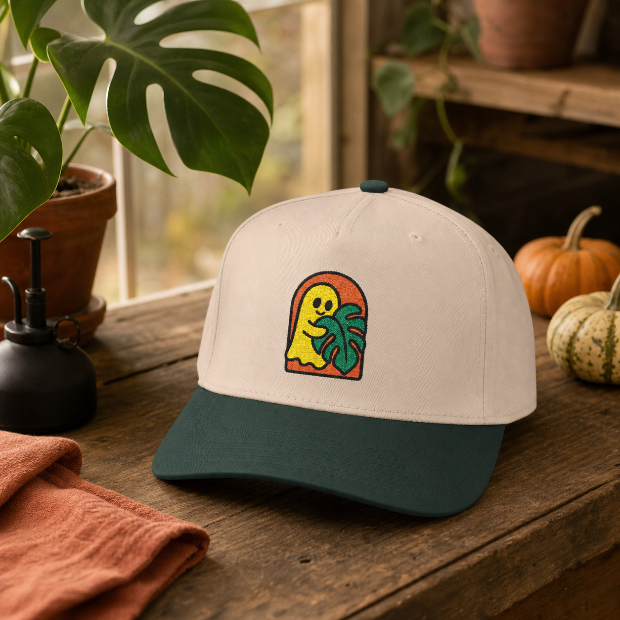 Ghost Monstera embroidered hat, Dark Green and Natural, in a greenhouse setting