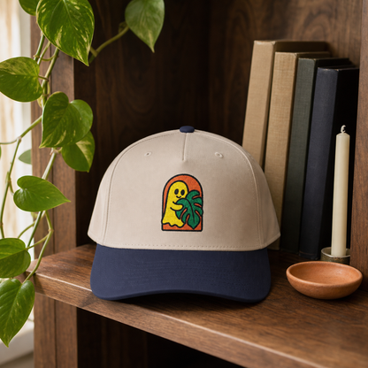 Ghost Monstera embroidered hat, Navy and Natural, in a blue tile sunroom