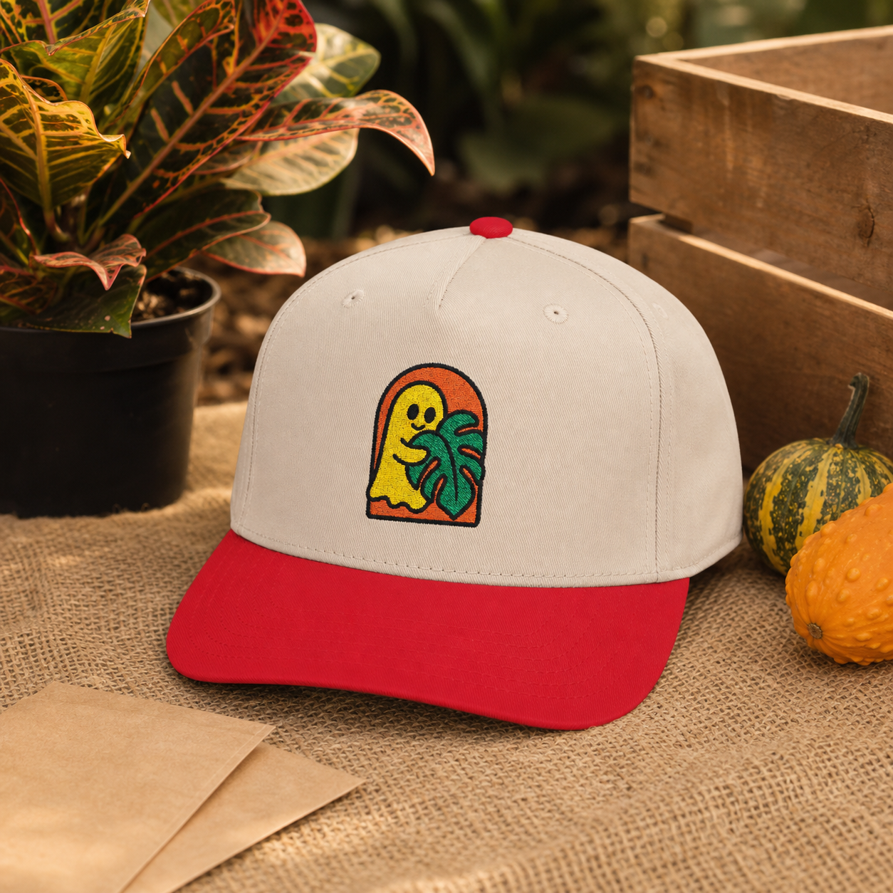 Ghost Monstera embroidered hat, Red and Natural, at an autumn plant market