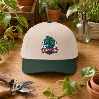 Plant Dad Hat in natural and forest green styled on a botanical potting bench